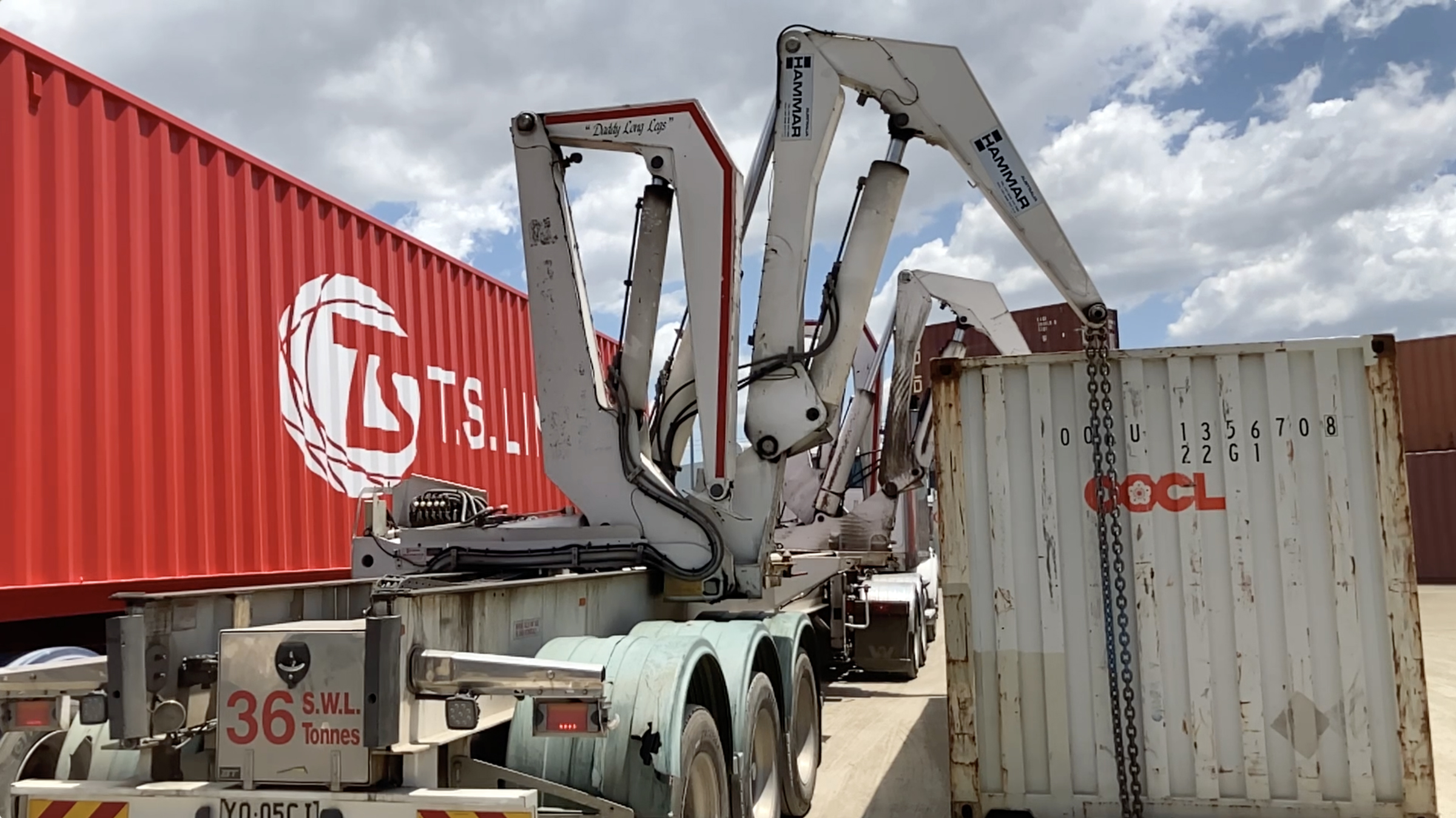 A container being lifted by huge hydraulic arms