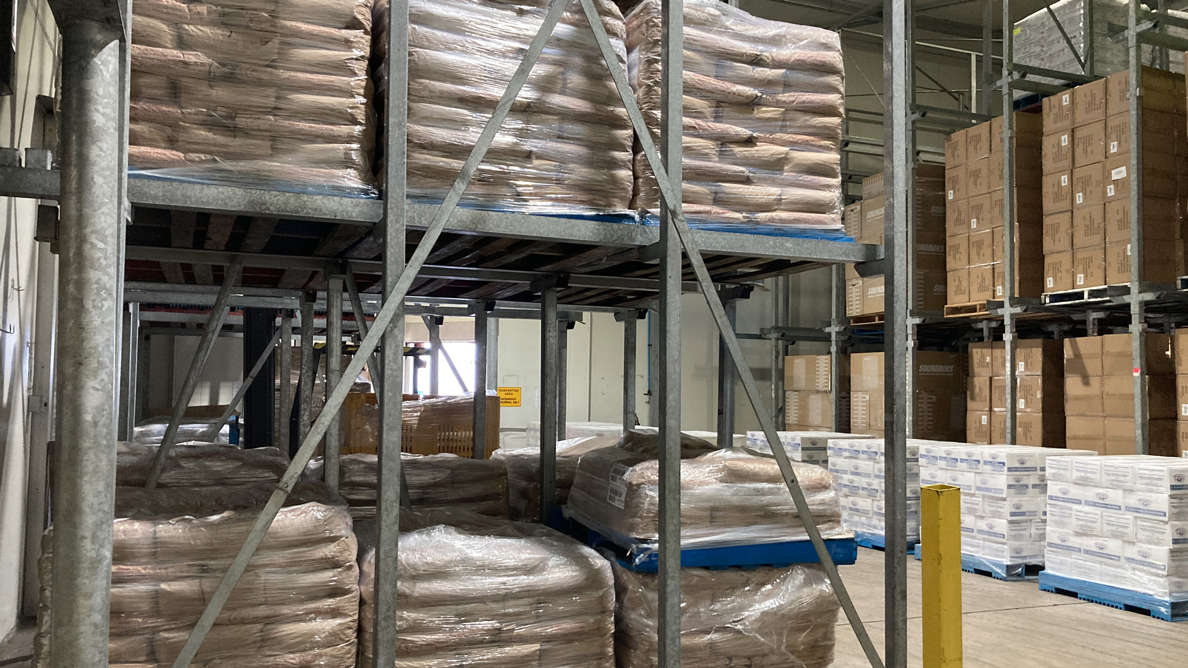 product stacked on metal shelves and pallets in a warehouse